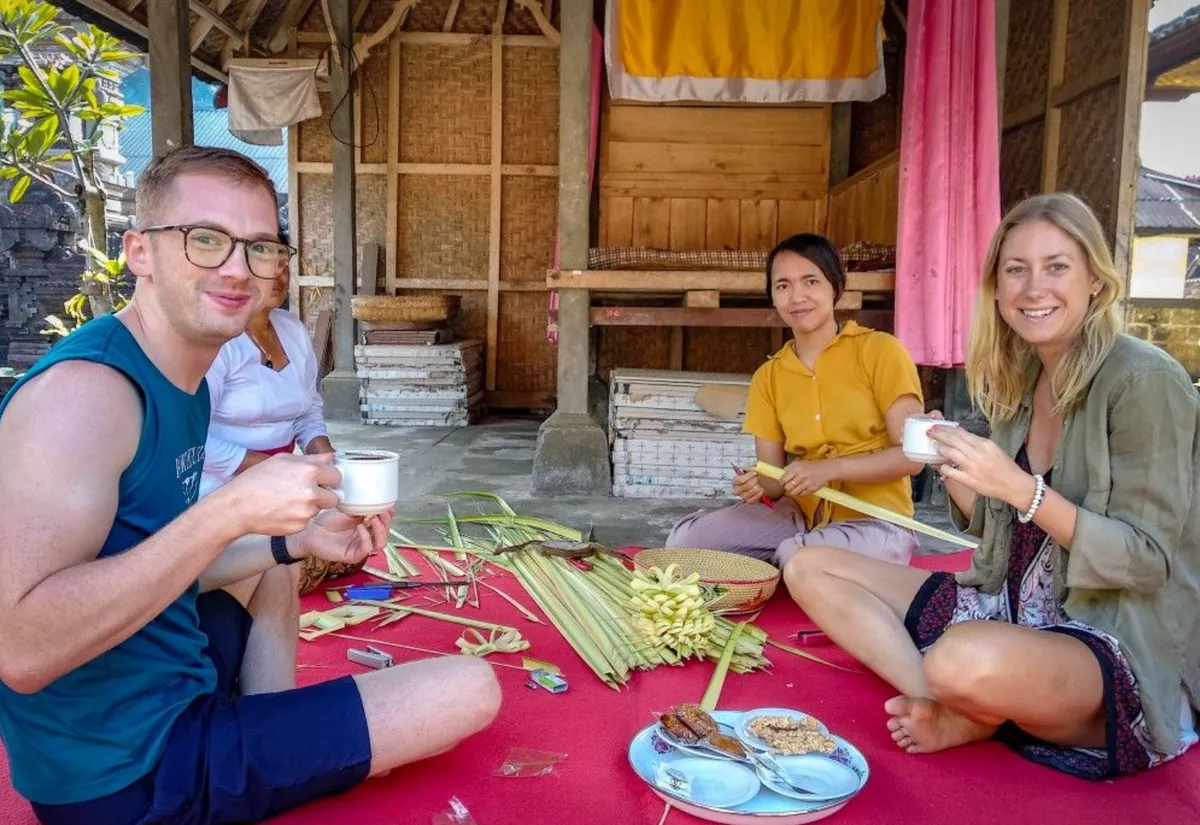 Guest learning to fold palm leaves during the offering workshop